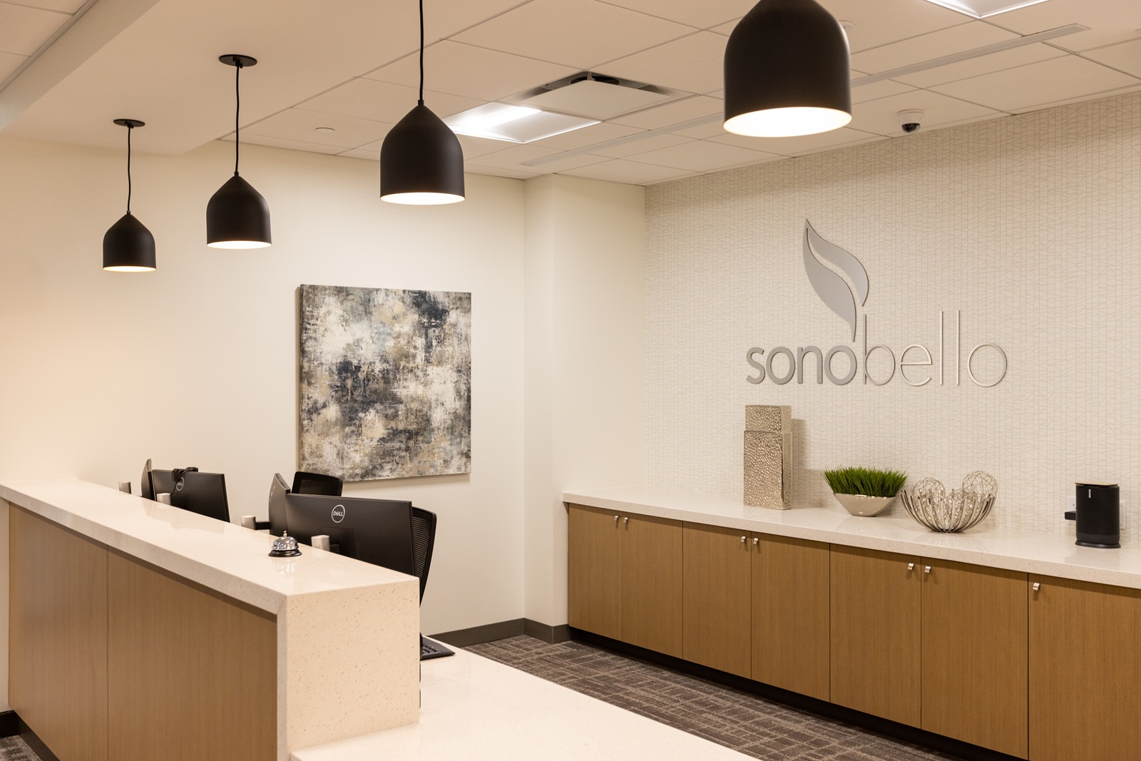 modern office reception with desks chairs overhead lights and wall art