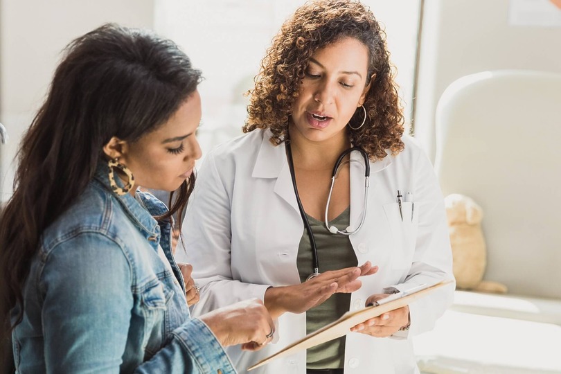 Patient and doctor discussing details about liposuction procedure