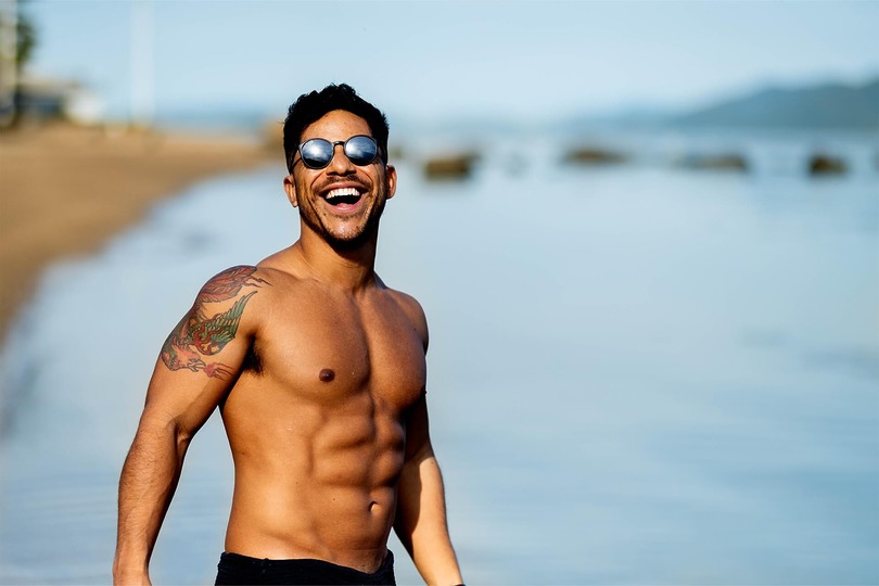 Man with sculpted chest and abs on the beach