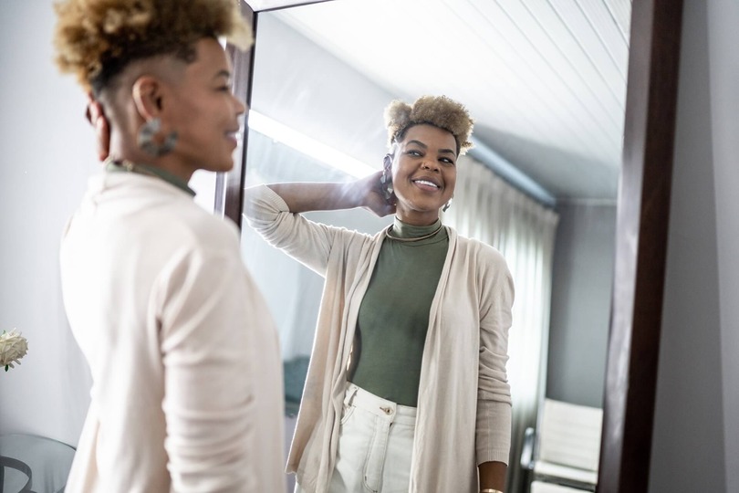 Woman admiring results after cosmetic procedure in mirror