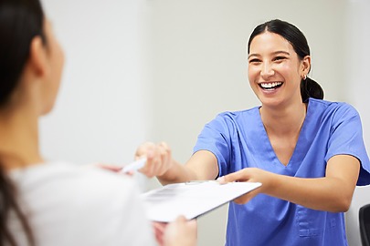 Medical professional sharing paperwork with patient to fill before procedure