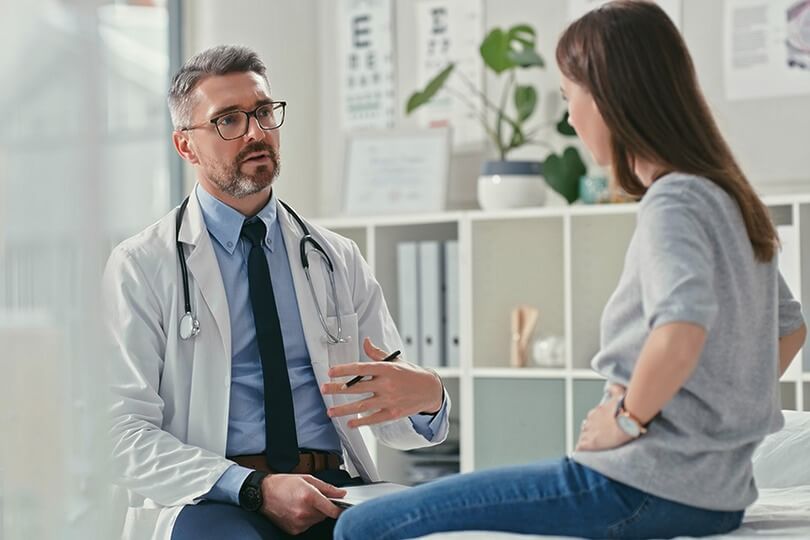 Surgeon consulting patient in medical setting