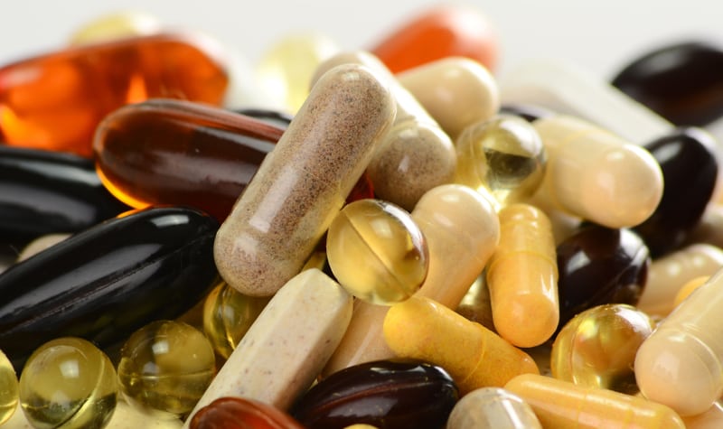 Various colorful dietary supplements and vitamins, including capsules and softgels, close-up view.
