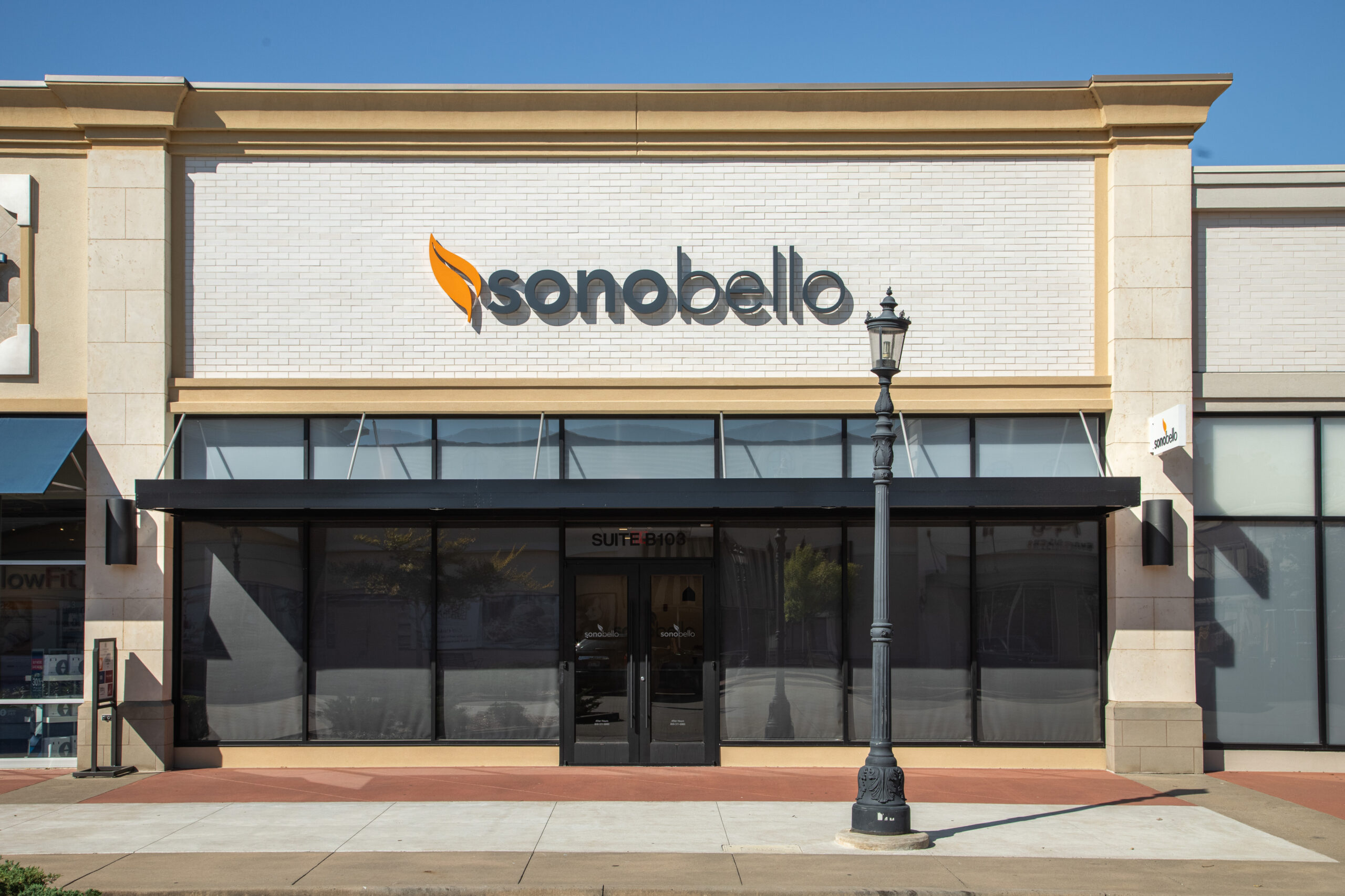 Exterior view of a Sono Bello clinic with signage on a sunny day.