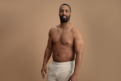 Male ambassador posing with sculpted abs and chest after liposuction