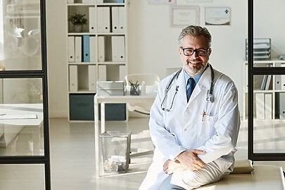 Male liposuction surgeon sitting in office