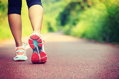 Close up of sneakers walking on sidewalk