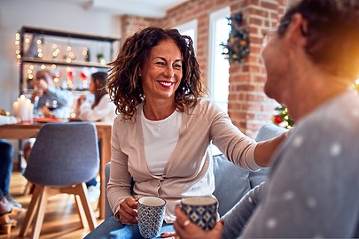 Middle-aged woman having coffee with family member