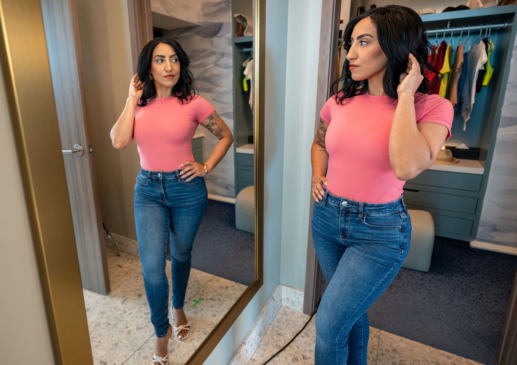 Sono Bello ambassador admiring post-liposuction results in the mirror