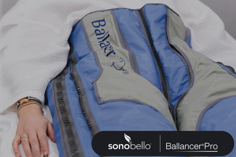 Person lying down wearing a blue BallancerPro compression suit with Sonobello logo visible.