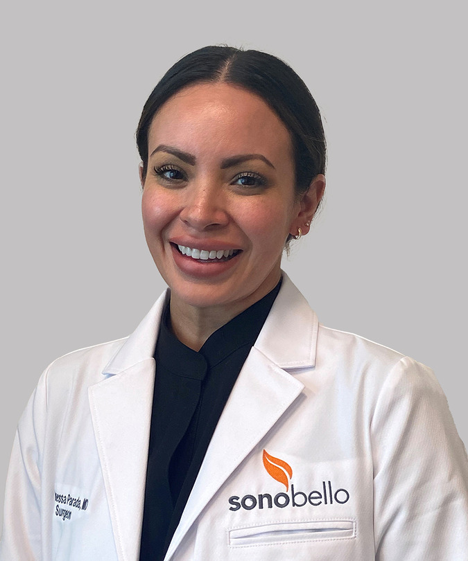 Doctor smiling in a white coat with Sonobello logo, against a neutral background.