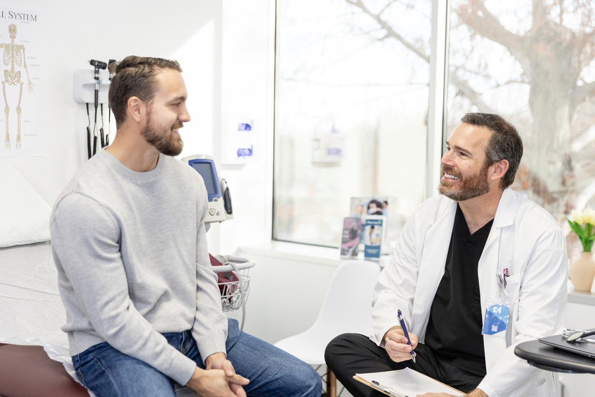 Doctor and patient smiling during a consultation in a bright medical office.