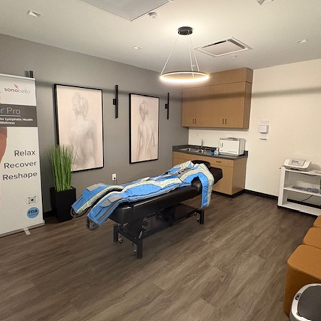 massage therapy room with treatment table, wall art, and a banner promoting relaxation and reshaping services