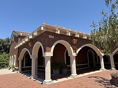 Sono Bello Chico liposuction and body contouring center with arches and columns under a clear blue sky. House number 194 visible on the corner.