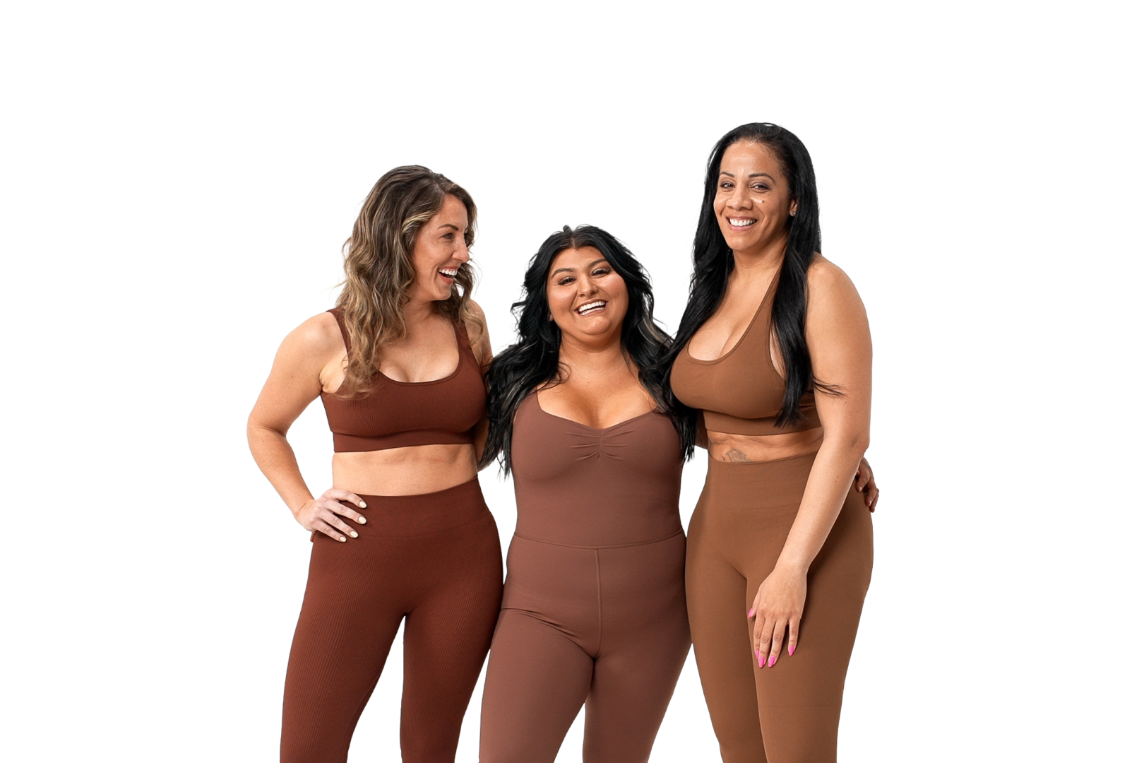 Three women laughing and wearing brown activewear, standing together against a white background.